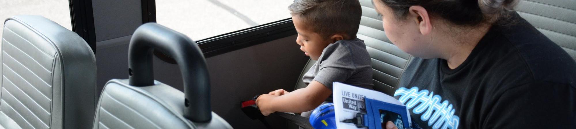 Preschool boy buckling his seatbelt on the bus.